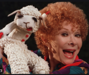 Shari Lewis smiling and holding her lambchop puppet 