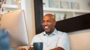 a man smiling while working on his computer