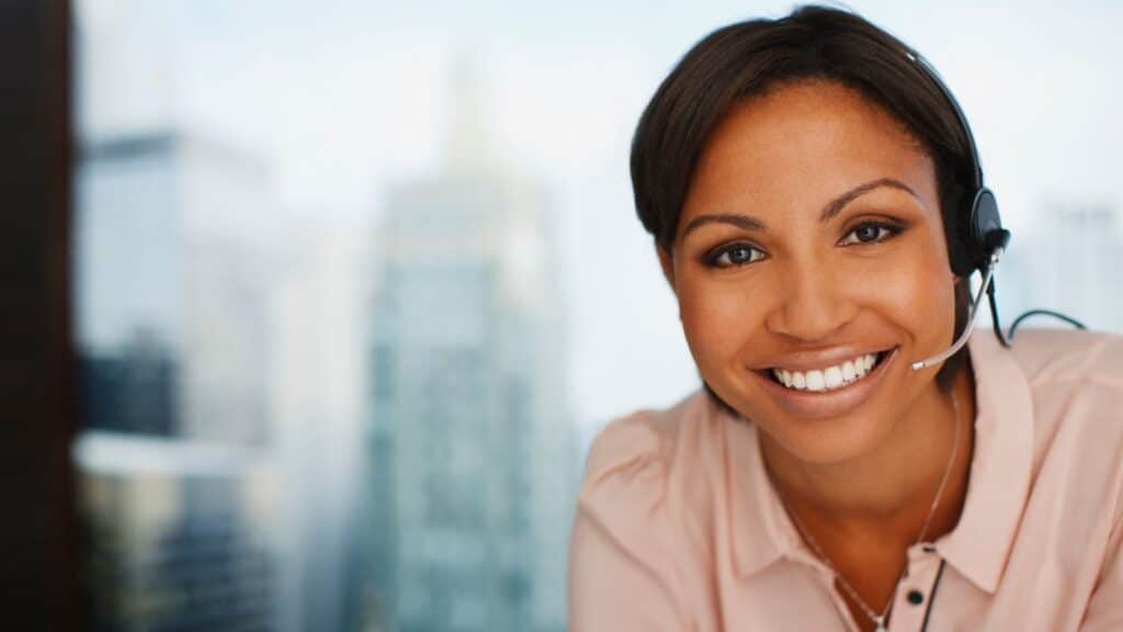 an african american woman wearing a headset and smiling 