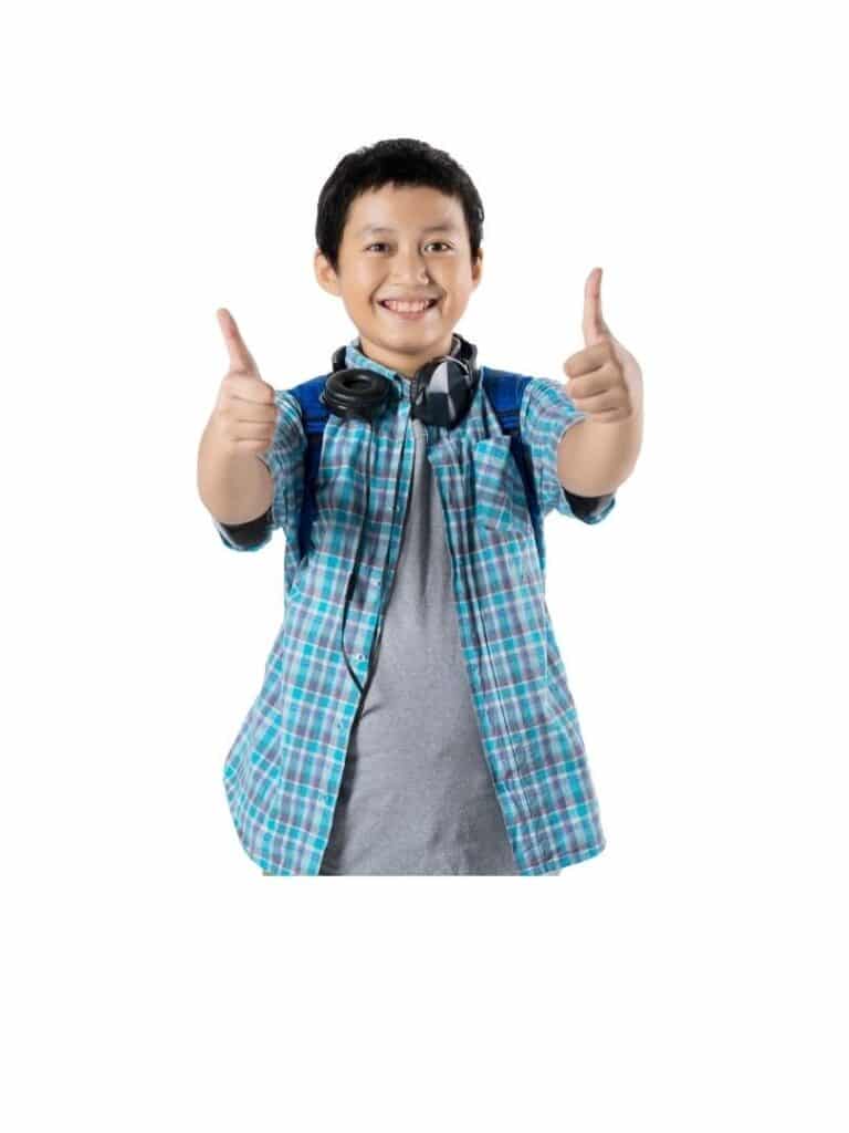a young boy giving two thumbs up and smiling while wearing headphones 