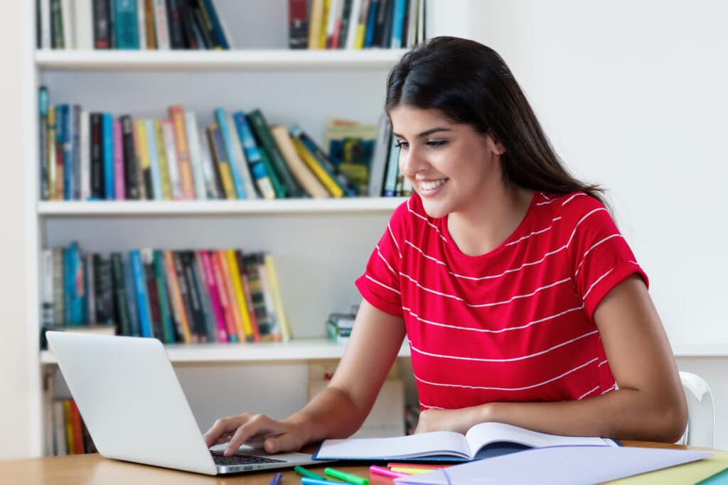 Mexican female student learning English on her laptop via video lessons