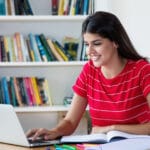 Mexican female student learning English on her laptop via video lessons