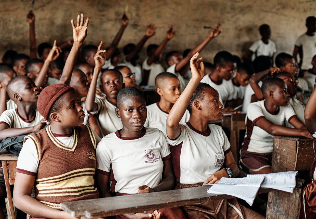 students at a school in Nigeria raising their hands
