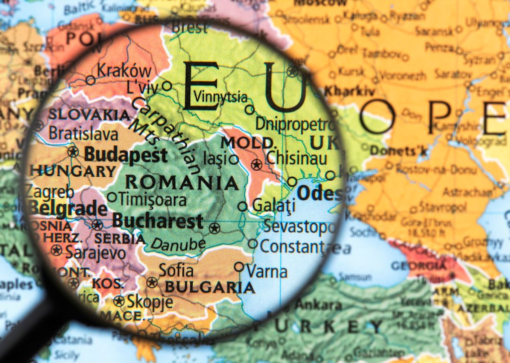 a map of Europe with the focus on Romania under a magnifying glass